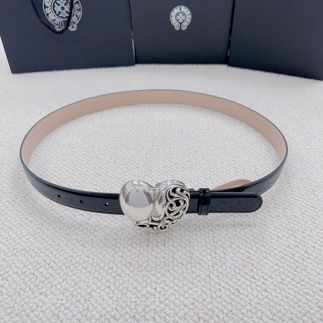 Chrome belt with black outer strap, tan lining, and centered silver heart buckle clasp.