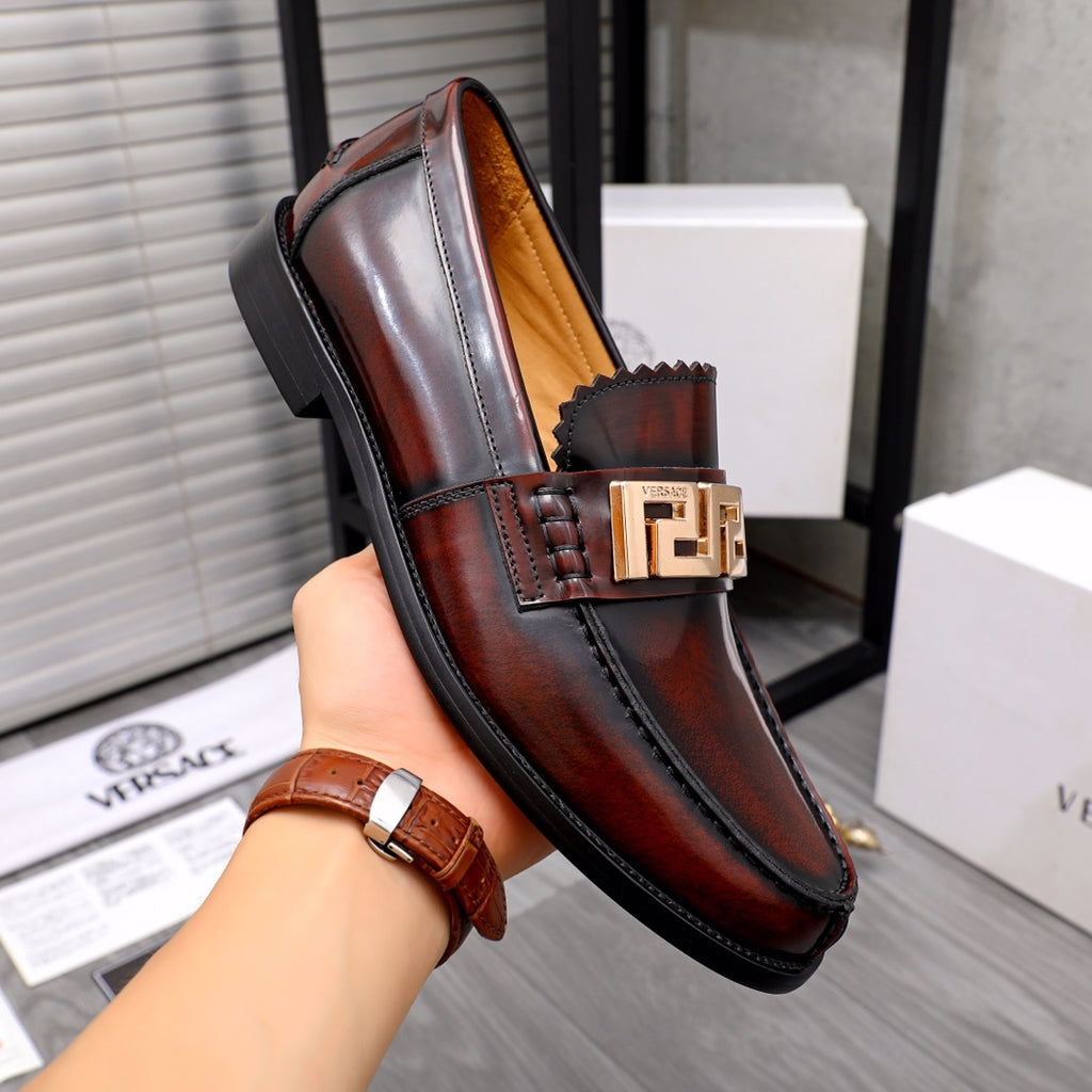 Versace leather loafer dark brown with gold buckle, held in hand
