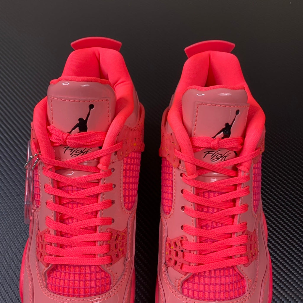 Pink Air Jordan 4 sneaker pair with heel tabs and red laces