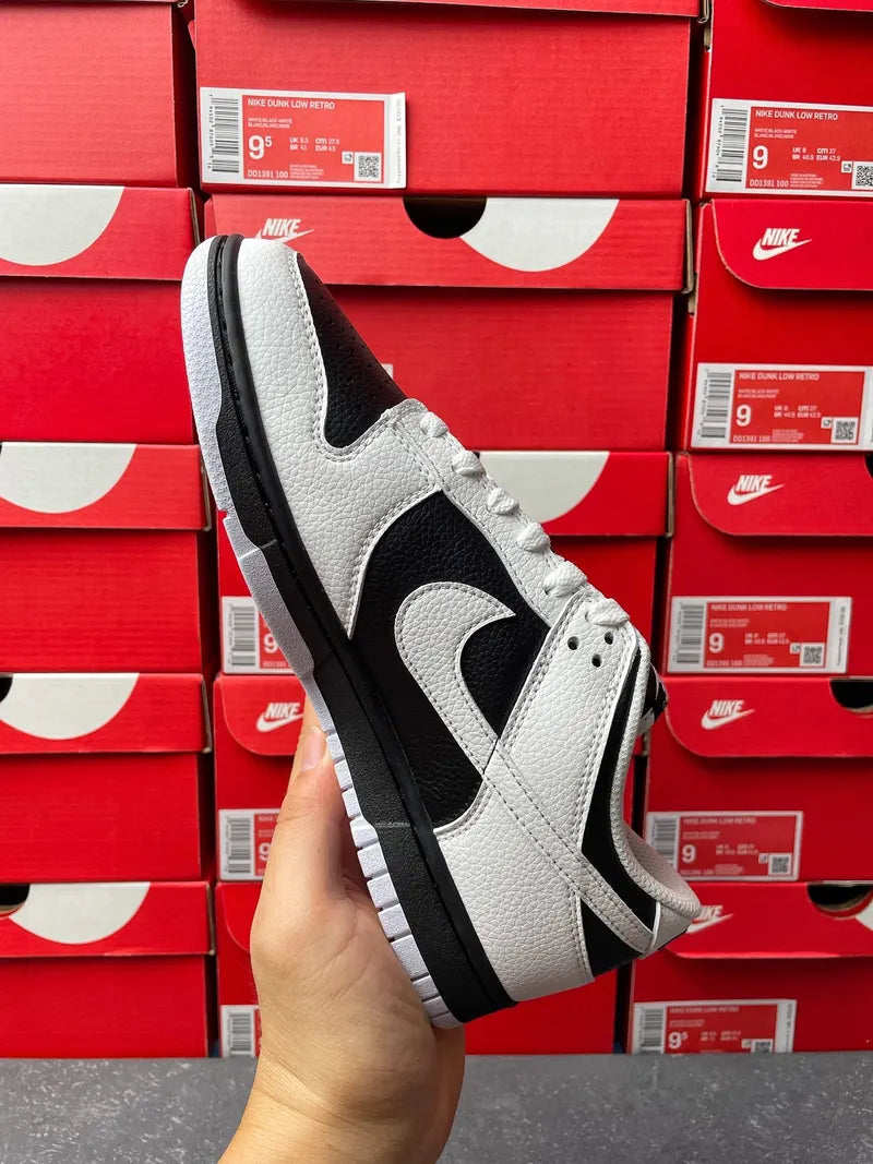 Nike Dunk Low sneakers, white leather upper with black paneling and dark rubber outsole
