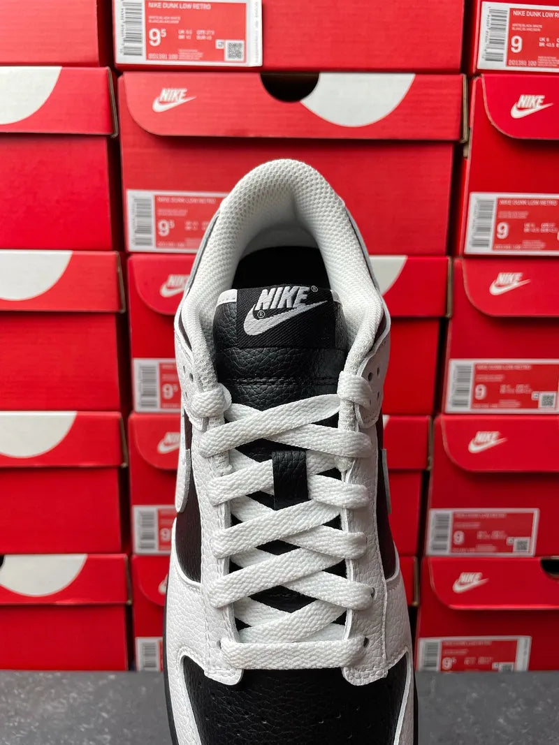 Nike Dunk Low sneakers, front view with white laces and black Nike tongue tag