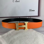 Orange leather belt with silver-tone H buckle and stitched edge