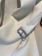 Cream long coat cuff with dark decorative buckle detail