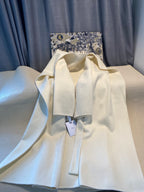 Cream long coat front view on hanger with Dior tags