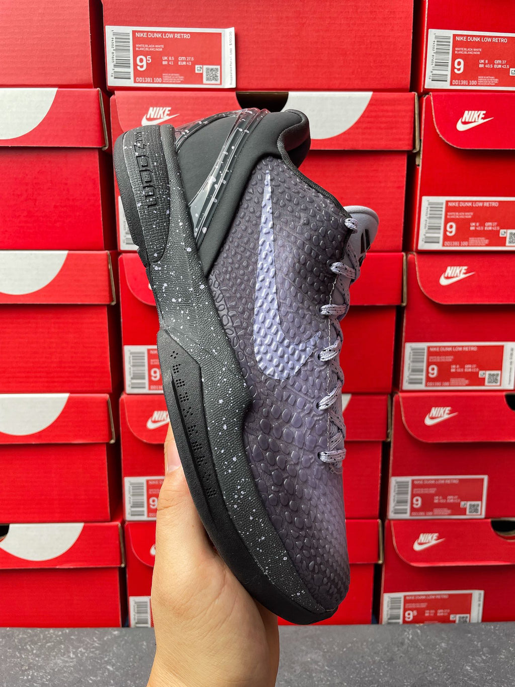 Basketball sneaker in dark gray with textured pattern, side view, lace-up closure.