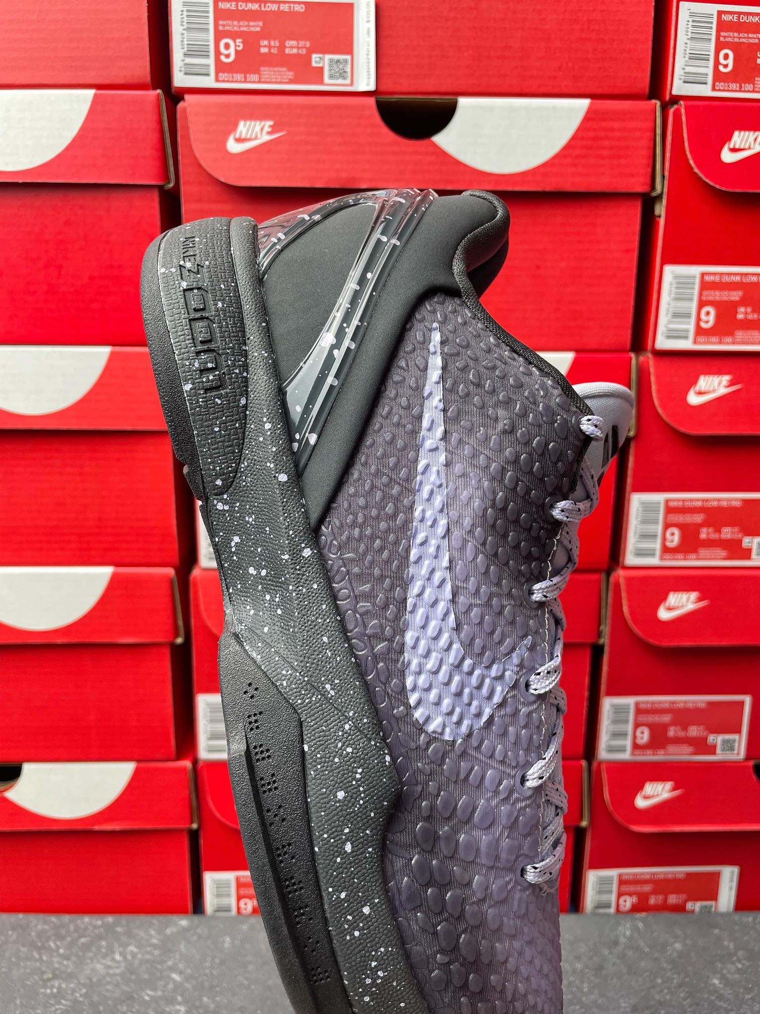 Basketball sneaker with textured dark gray upper and black outsole, lace-up front.