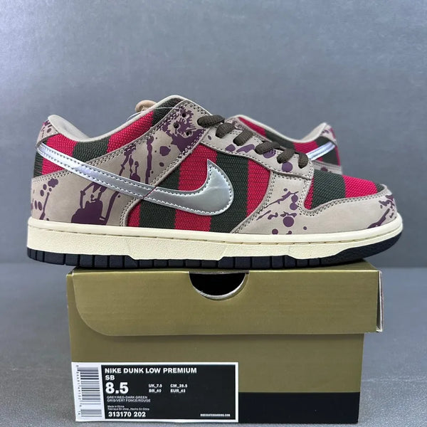 Low-top sneakers side view on box; cream leather with red and green panels; purple splatter