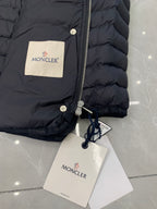 Moncler puffer jacket close-up with front zipper, drawcord hood, and tags