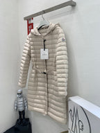 Long beige quilted puffer coat on hanger with hood and front zipper closure
