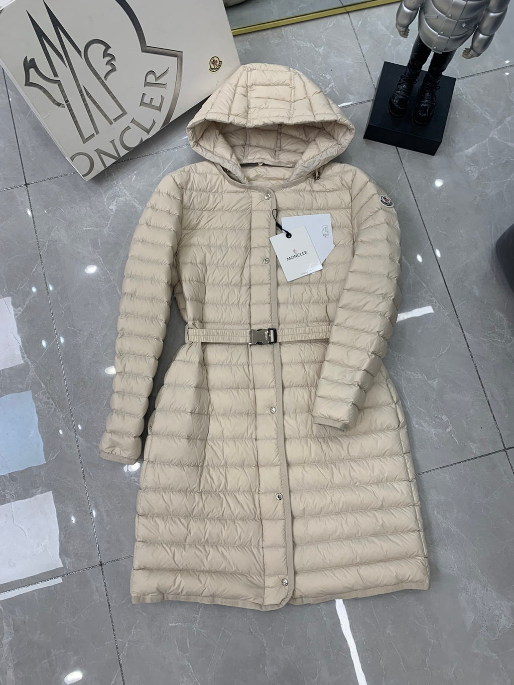 Long beige quilted puffer coat with hood and front buttons plus belt strap