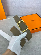 Hermes leather belt with olive strap and gold buckle, shown laid on fabric