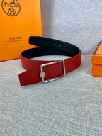 Hermes belt red leather with silver buckle, shown laid flat on gray surface