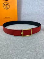 Hermes belt red and black leather with gold rectangular buckle, laid flat
