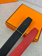 Hermes belt set: dark navy and red leather straps with gold buckles on display