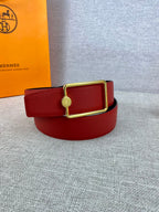 Hermes belt red leather with gold rectangular buckle, angled view