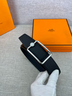 Navy leather belt with silver rectangular buckle and round emblem center