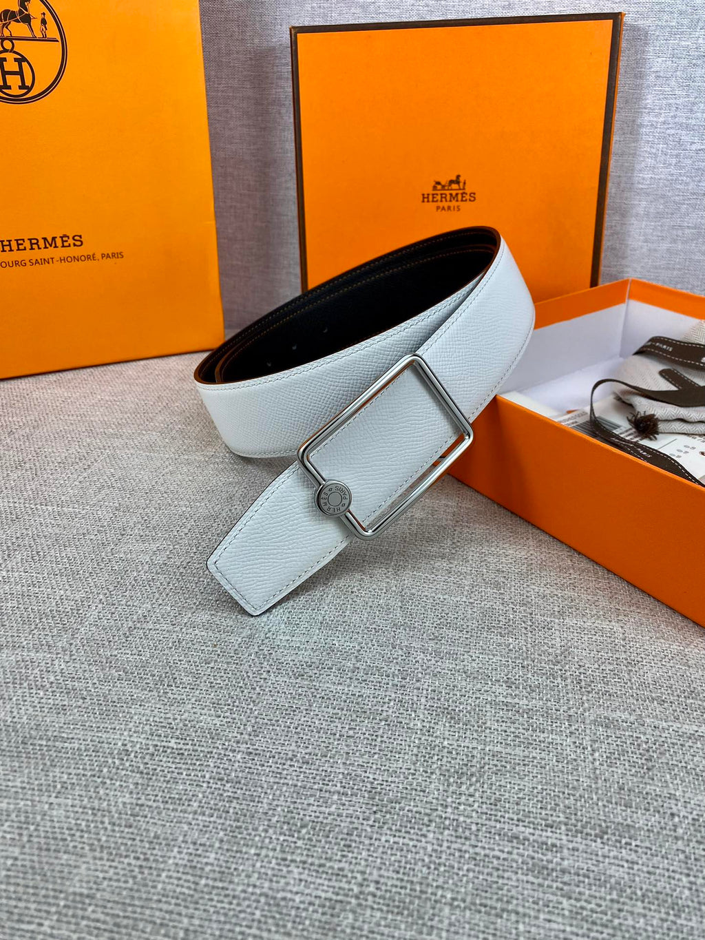 Light blue leather belt with silver rectangular buckle and short keeper tab.
