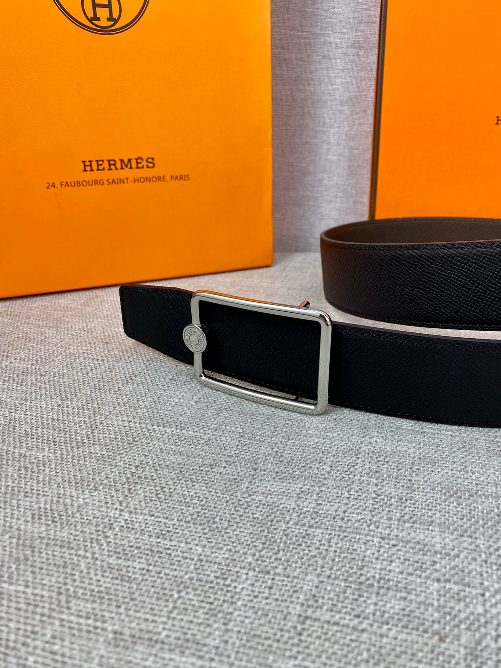 Hermes belt in dark leather with silver rectangular buckle and round emblem