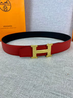 Hermes belt with red strap and gold-tone H buckle, black inner side visible