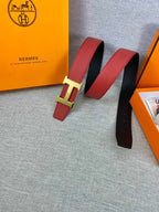 Hermes belt pair view: red leather with gold-tone H buckle, black underside visible