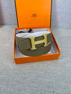 Olive leather belt laid in gift box with gold-tone buckle and white interior
