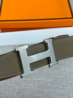 Olive leather belt showing adjustable holes and silver-tone buckle close-up