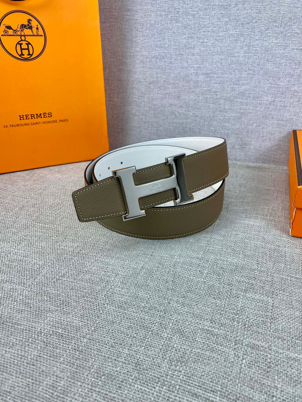Olive leather belt with smooth white edge and metal H-shaped buckle