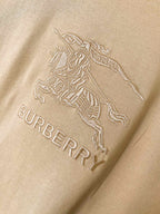 Tan Burberry T-shirt close-up of horse rider emblem and 'BURBERRY' text
