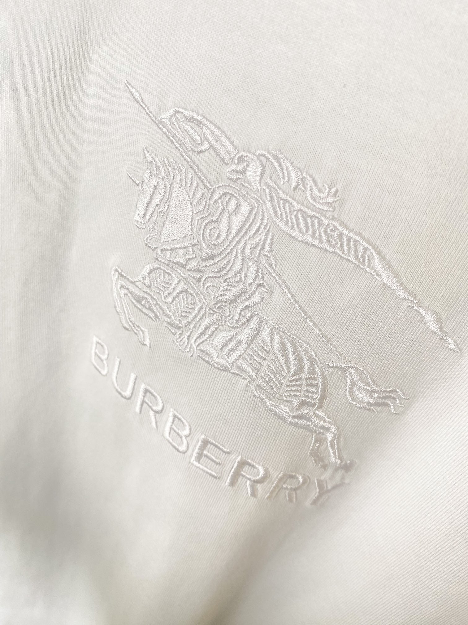 Embossed horse-and-rider graphic with “BURBERRY” text on white T-shirt