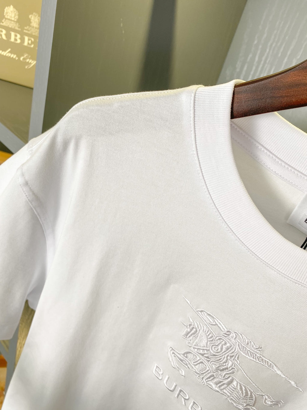 White T-shirt with crew neck collar and embossed logo graphic on the chest
