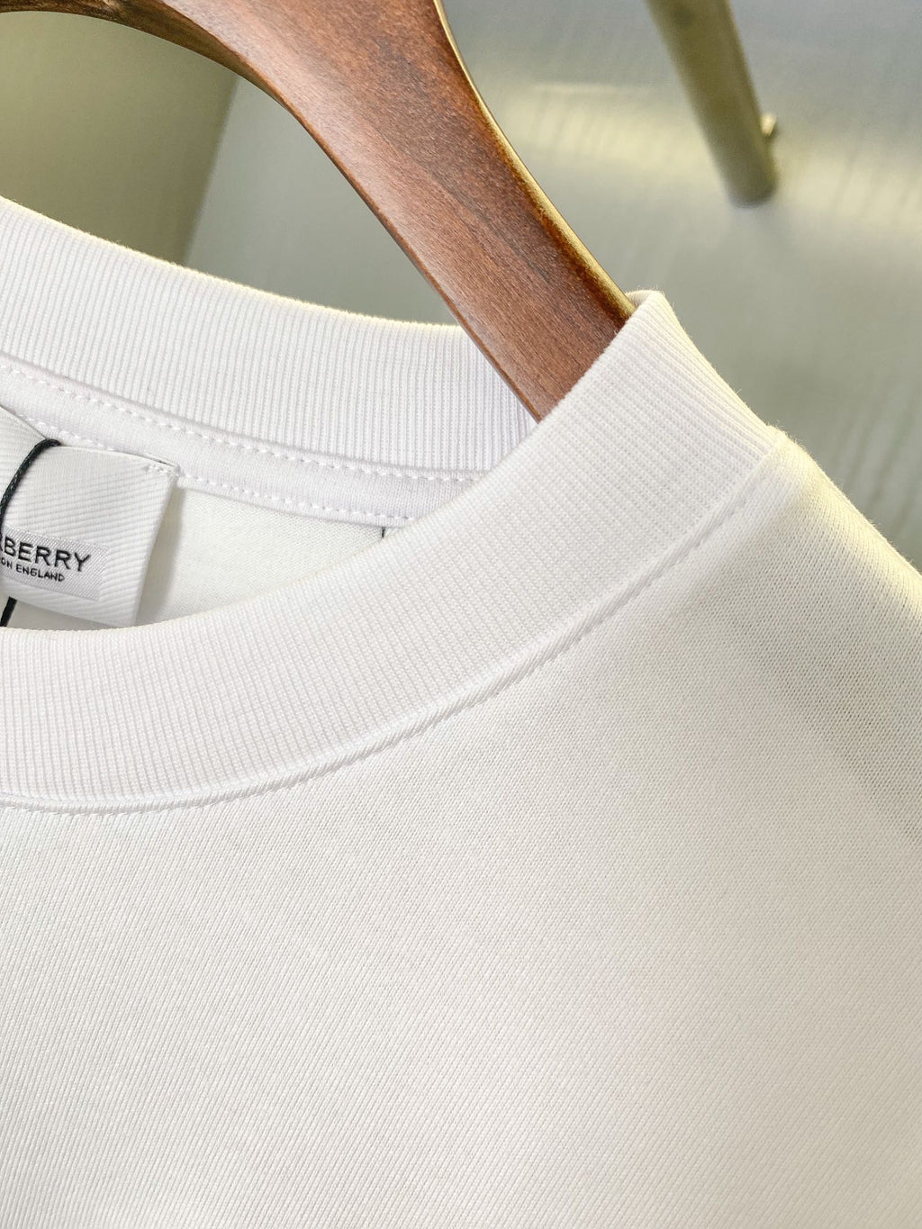 White crew-neck T-shirt collar with smooth neckline stitching and partial logo inside label