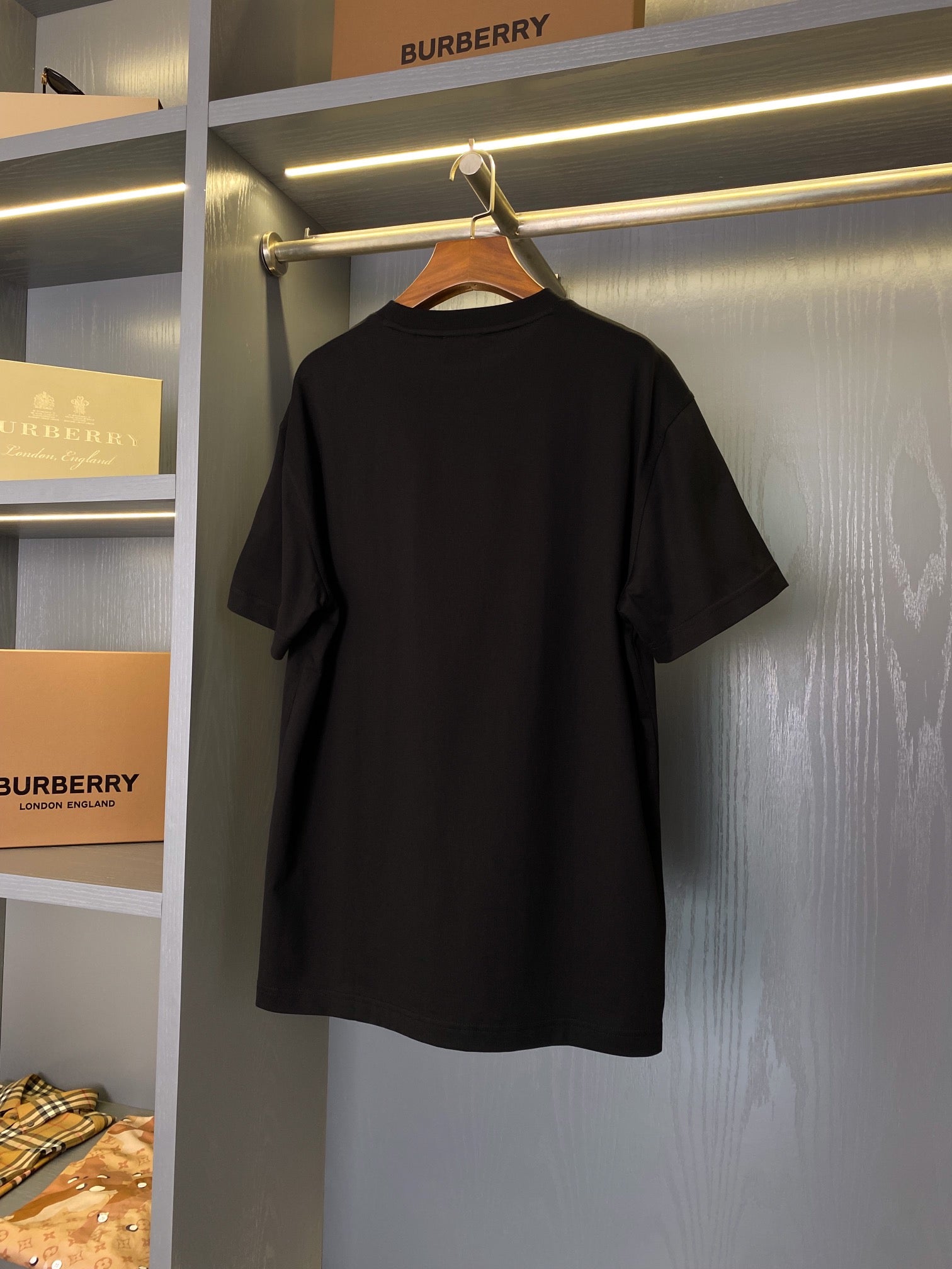 Back of black short-sleeve T-shirt on a hanger