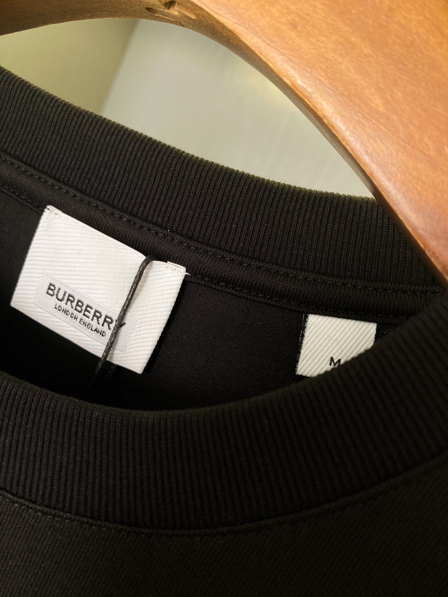Black T-shirt neckline with inner brand label and collar ribbing