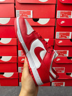 Nike Dunk Low low-top sneaker three-quarter view with red leather quarter and white swoosh