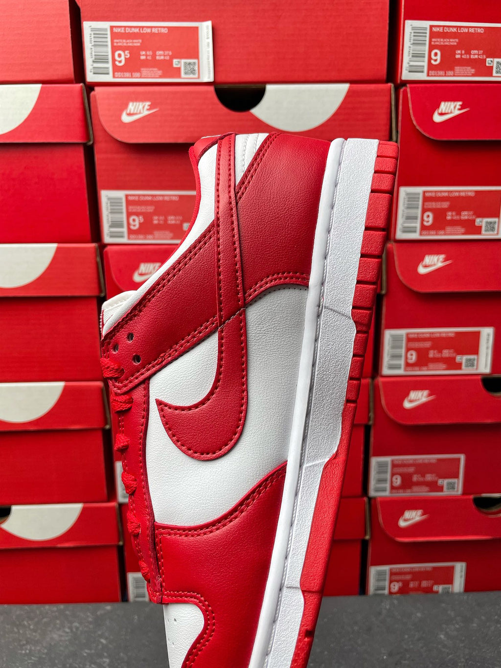 Nike Dunk Low low-top sneaker quarter view showing red and white panels and white midsole