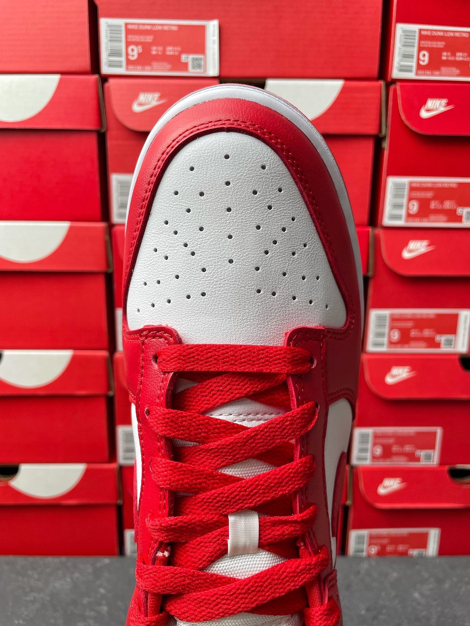 Nike Dunk Low low-top sneaker top view with red laces and perforated white toe box