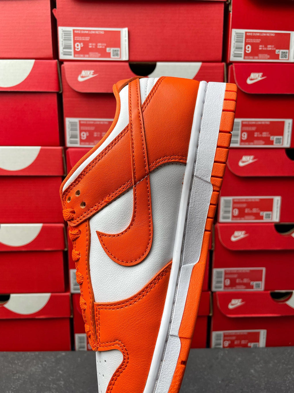 Orange and white low-top sneakers with padded collar and orange lace-up detail