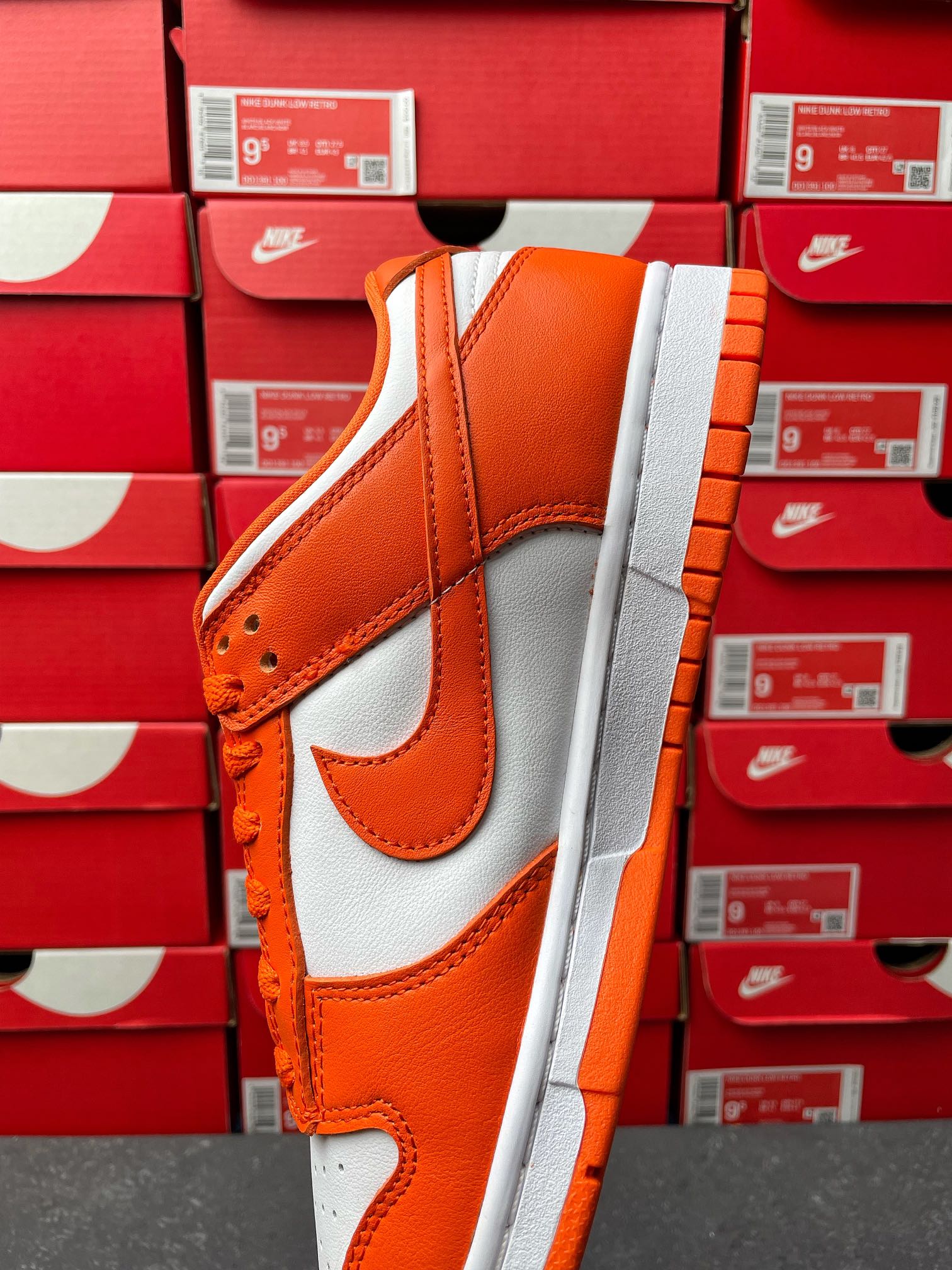 Orange and white low-top sneakers with padded collar and orange lace-up detail