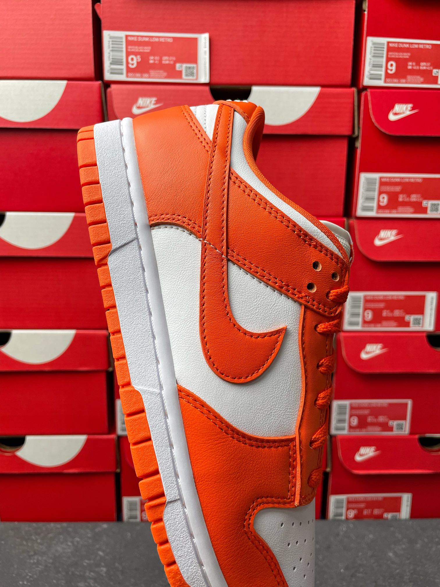 Orange leather and white panel low-top sneakers with swoosh detail and lace-up