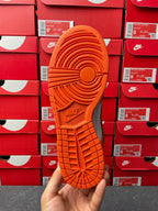 Orange outsole of low-top sneakers with grippy tread and NIKE branding