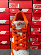 Orange low-top sneakers with white heel panel and orange lace-up
