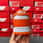 Back view of orange low-top sneakers with NIKE branding and white rubber sole