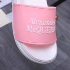 Alexander McQueen slide sandal close-up: pink logo strap on white footbed