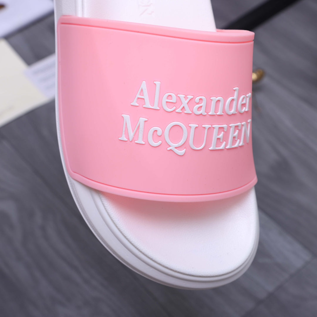 Alexander McQueen slide sandal close-up: pink logo strap on white footbed