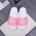 Alexander McQueen slide sandals with white footbed and pink logo strap band