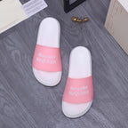 Pair of Alexander McQueen slide sandals, white uppers with pink logo strap