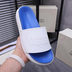 Alexander McQueen slide sandal in white with blue footbed and embossed logo