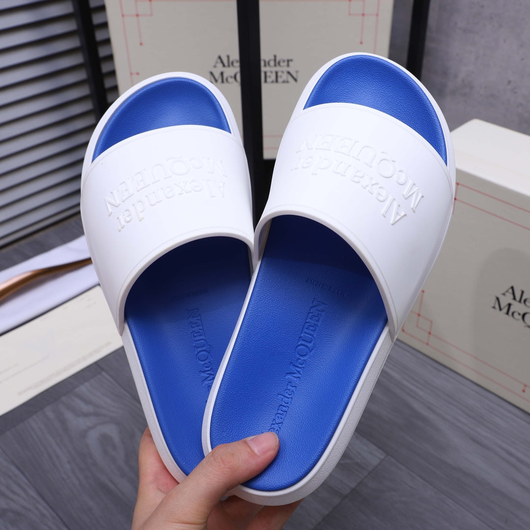 Alexander McQueen slides showing white strap and blue footbed, embossed branding