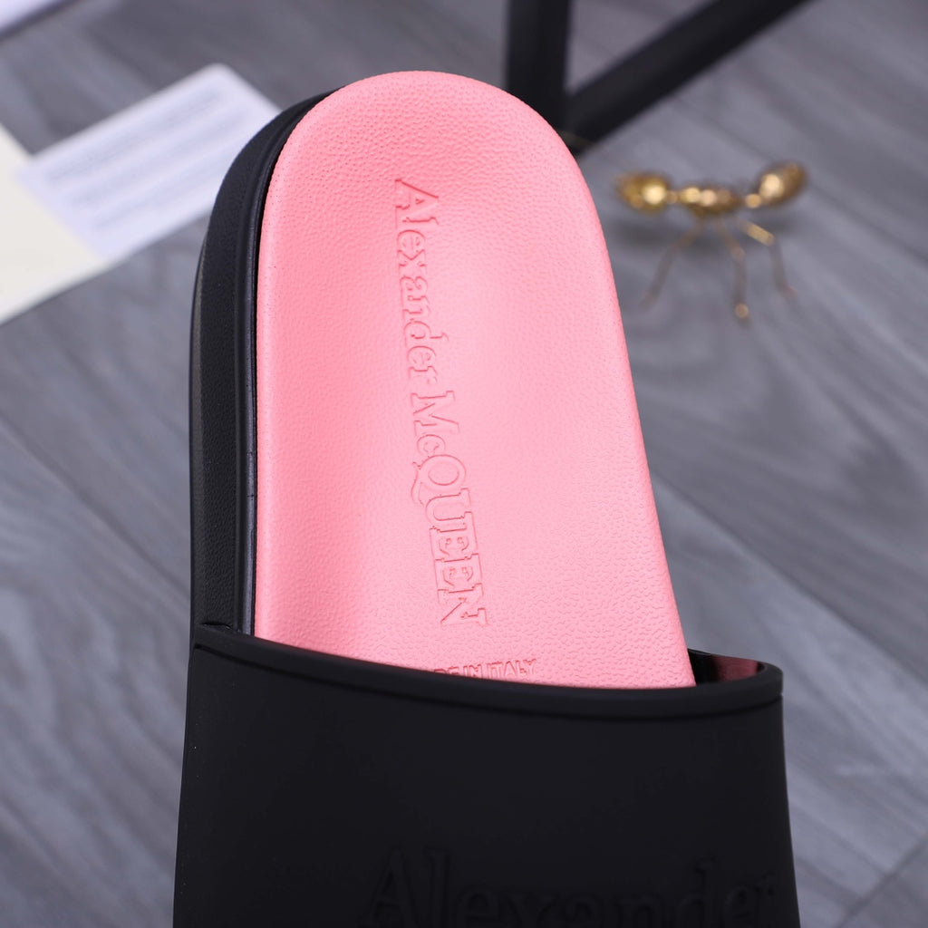 Close-up of pink insole inside a black slide sandal; embossed Alexander McQUEEN text