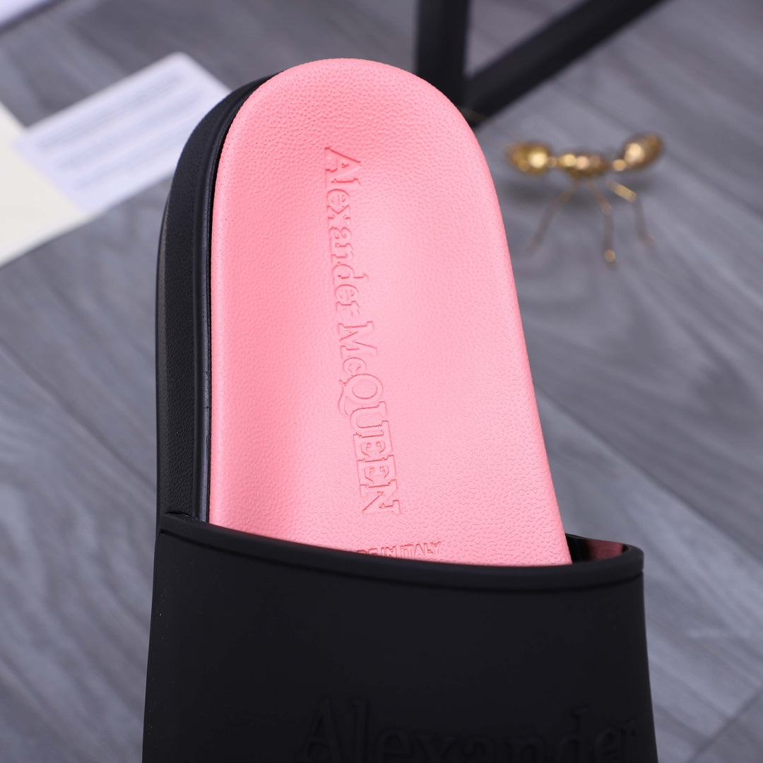 Close-up of pink insole inside a black slide sandal; embossed Alexander McQUEEN text
